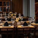 A beautifully arranged dining table with elegant glassware and floral centerpieces set for a special occasion.